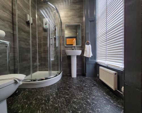 a bathroom with a shower and a sink and a tub at Stay - NO59 in Edinburgh