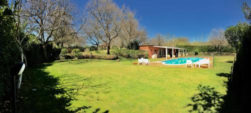 een grote tuin met een zwembad en een huis bij Country House Etna Glicine in Piedimonte Etneo