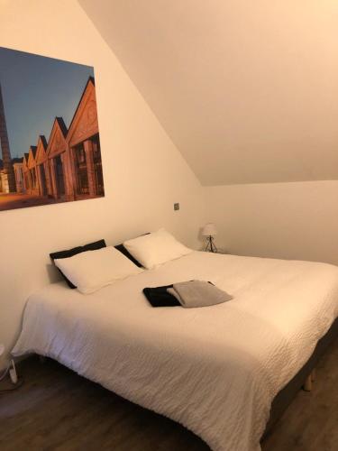 - une chambre avec un lit blanc orné d'une peinture murale dans l'établissement LE GITE LACHELLE, à Lachelle