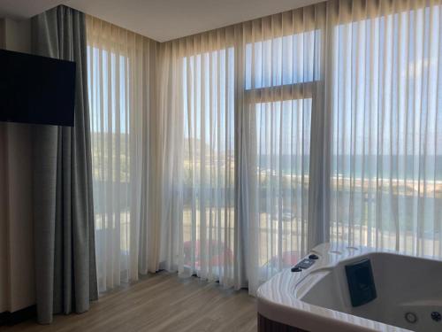 a bathroom with a tub and a large window at Hotel A Ladela in O Vicedo