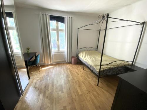 een kamer met een bed, een bureau en ramen bij Beautiful lake view house in Västerås