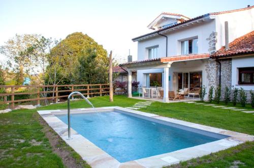 une piscine dans la cour d'une maison dans l'établissement Wishome-Casa con piscina climatizada, cerca Comillas, à Valdaliga 