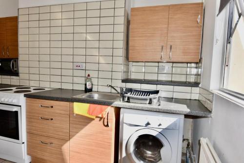 a kitchen with a sink and a washing machine at Come on in Lucas Street Newport Train Station Sleep upto 8 in Newport