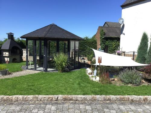 a garden with a gazebo in the yard at Ferienwohnung Entenquack in Weisel