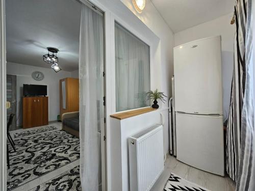 a kitchen with a refrigerator and a living room at Cluj Zorilor Residence in Cluj-Napoca