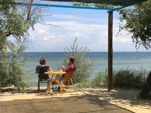 two people sitting at a table looking at the ocean at Hotel Villa Sevasti in Katerini