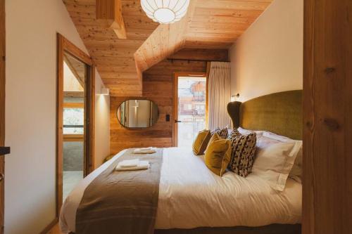 a bedroom with a large bed with a wooden ceiling at Appartement de charme Chantemerle in Saint-Chaffrey
