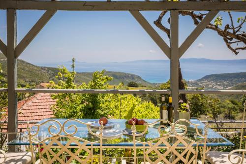 a table and chairs on a porch with a view at Sandy & Sofia in Katelios
