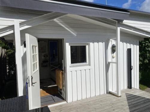 a white shed with a door on a deck at Studio 51 Örgryte in Gothenburg