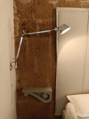 a bathroom with a light on a brick wall at BB Orvieto in Orvieto