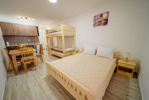 een slaapkamer met een groot bed en een keuken bij Apartmani Šarović Tara 2 in Rača