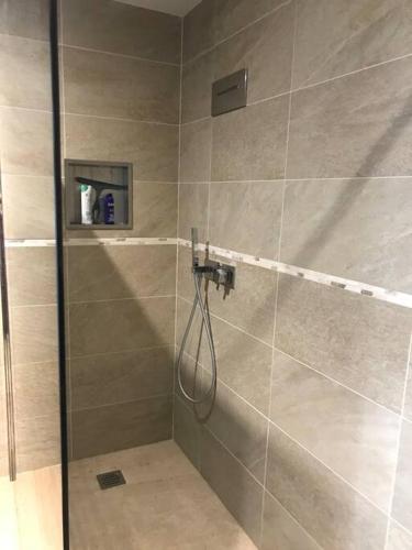 une douche avec un tuyau dans une salle de bain dans l'établissement Appartement en bas de villa, à Ocana