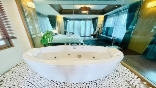 a large bathroom with a white bath tub in a room at Yizen Beachfront Seaview Villa in North Pattaya