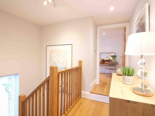 a room with a staircase with a table and a lamp at Luxurious apartment, 180° beach views & parking in St Ives