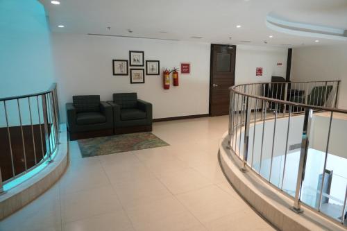 a living room with a couch and a staircase at Four Points by Sheraton Vadodara in Vadodara