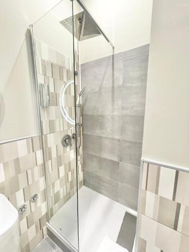 a shower with a glass door in a bathroom at Regina Elena Rooms in Pescara