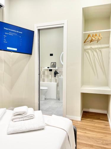 a white room with a bed and a bathroom at Regina Elena Rooms in Pescara