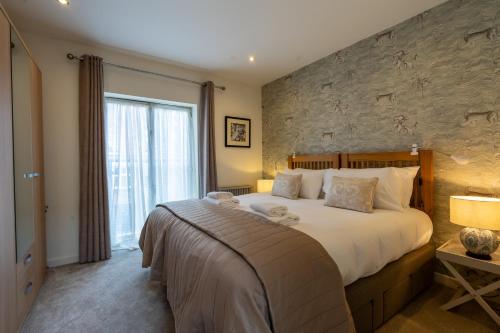 a bedroom with a large bed and a stone wall at 11 Stonegate Court in York