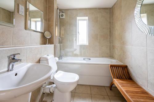 a bathroom with a tub and a toilet and a sink at 11 Stonegate Court in York
