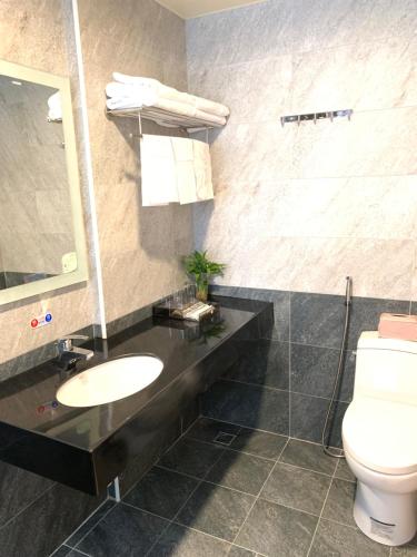 La salle de bains est pourvue d'un lavabo et de toilettes. dans l'établissement Kinmen Happiness Shop, à Jinning