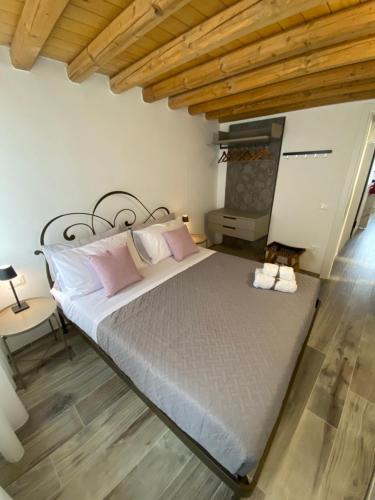 a large bed in a room with a wooden ceiling at Elva Suite House in Chioggia