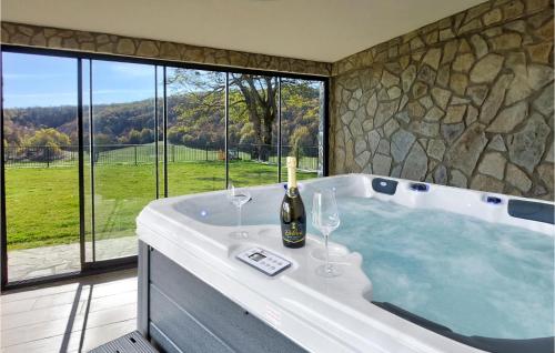 a bath tub with two wine glasses and a bottle of champagne at Awesome Home In Barlete With Kitchen 