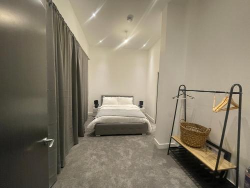 a bedroom with a bed in a white room at Luxury 2 bedroom Flat Sutton in Sutton