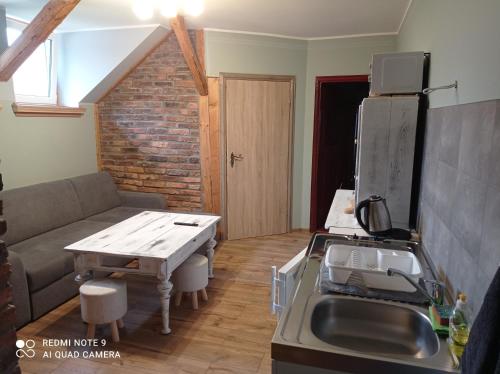 a kitchen and living room with a couch and a table at Apartamenty w Karkonoszach in Lubawka