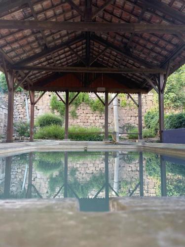 un grand bassin d'eau avec un toit en bois dans l'établissement Au Perchoir, à Caunes-Minervois