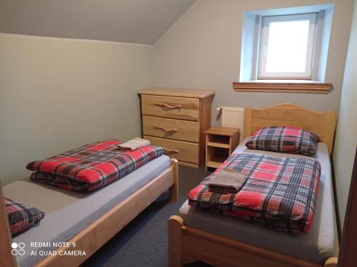 a bedroom with two beds and a dresser at Apartamenty w Karkonoszach in Lubawka