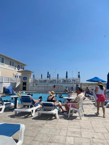 a group of people sitting in chairs near a swimming pool at The White Sands Resort and Spa in Point Pleasant Beach