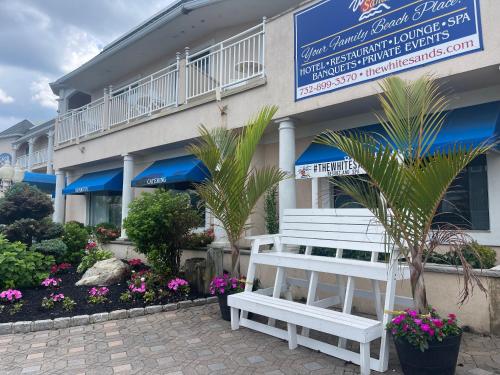 a white bench sitting in front of a building at The White Sands Resort and Spa in Point Pleasant Beach