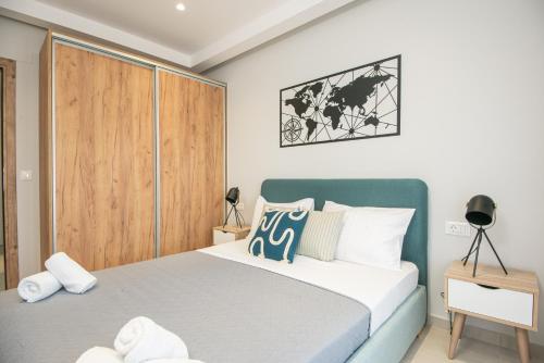 Schlafzimmer mit einem Bett und einem Holzschrank in der Unterkunft Mylos Luxury Apartment 4 in Agios Nikolaos