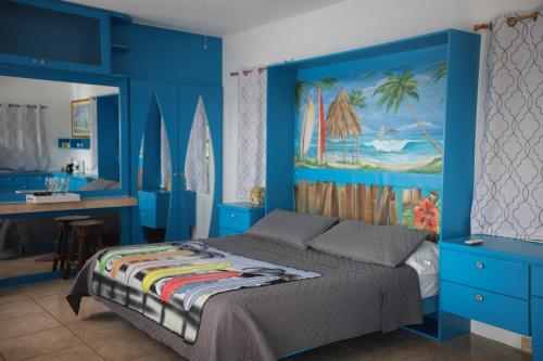- une chambre bleue avec un lit et un bureau dans l'établissement Vista del Mar terrace with pool table and views, à Rincon
