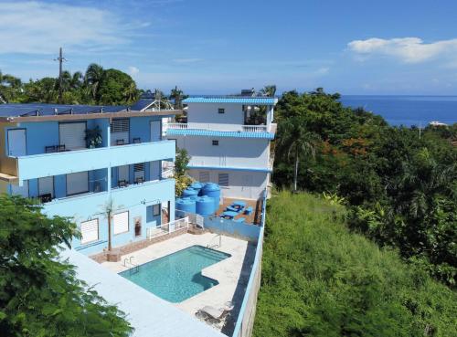 - une vue aérienne sur une maison avec une piscine et l'océan dans l'établissement Vista del Mar terrace with pool table and views, à Rincon