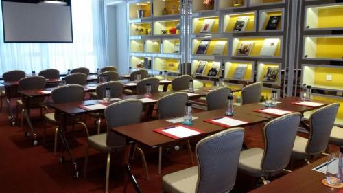 a conference room with tables and chairs and a screen at Hotel Indigo Hong Kong Island by IHG in Hong Kong