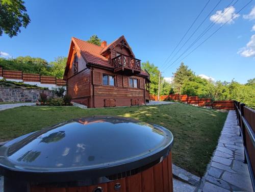 una casa con bañera de hidromasaje en el patio en Bug Na Skarpie - Domek Wypoczynkowy z Jacuzzi i Kominkiem en Drohiczyn nad Bugiem