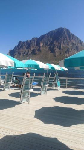 a row of chairs and umbrellas on a beach at Casa Regina in Castelluzzo