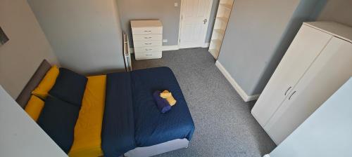 a small bedroom with a blue bed and a drawer at Spacious large Room In Nottingham 005 in Nottingham