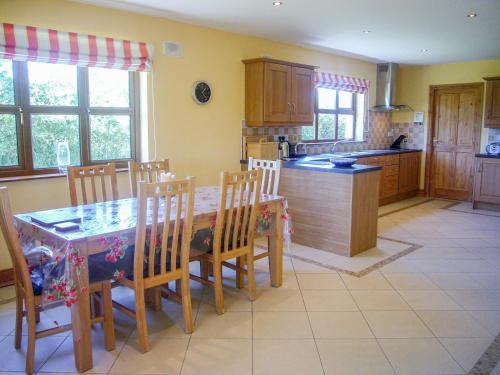 a kitchen with a table and chairs and a kitchen with yellow walls at Tra Gheal in Kilmore Quay