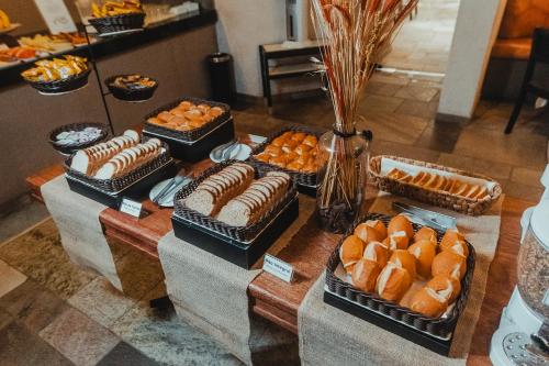 a table filled with different types of bread and pastries at Ferraretto Guarujá Hotel & Spa in Guarujá