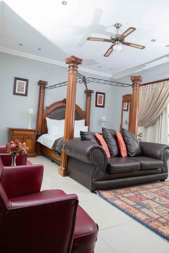 a living room with a bed and a leather couch at The Afropolitan in Johannesburg