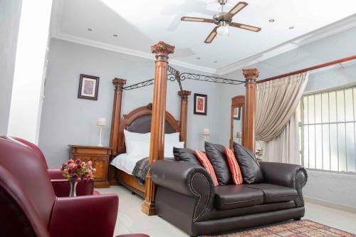 a bedroom with a bed and a couch and a chair at The Afropolitan in Johannesburg