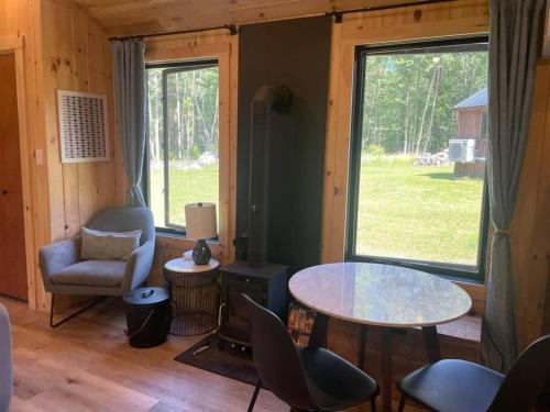sala de estar con mesa, sillas y ventana en Vermont Scandinavian Chalet-Courchevel en Wolcott