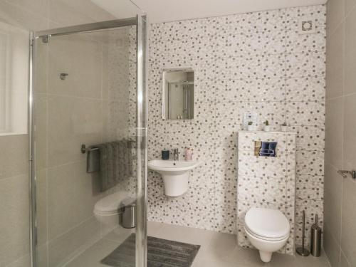 La salle de bains est pourvue d'une douche, de toilettes et d'un lavabo. dans l'établissement Beach House, à Gorey
