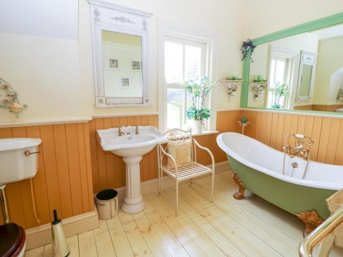 a bathroom with a tub and a sink and a bath tub at Glasmor Country House in Fieries