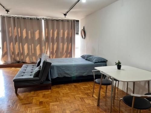 a bedroom with a bed and a couch and a table at Loft Mirante 3224 in Sao Paulo