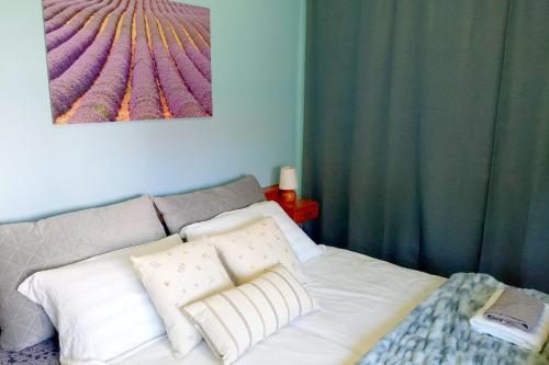 a bed with white pillows and a painting on the wall at Sobe Zimmer Rooms Živčić in Karlovac
