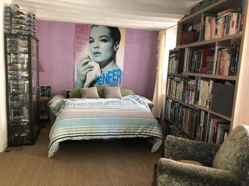 ein Schlafzimmer mit einem Bett und einem Poster einer Frau in der Unterkunft Grande maison avec jardin arboré in Survilliers