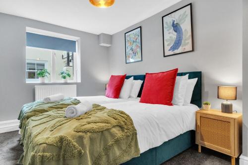 a bedroom with a large bed with red pillows at Valley Garden View 1 By My Getaways in Brighton & Hove